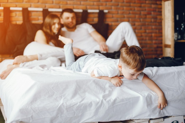 family-sitting-in-a-bed_1157-16996